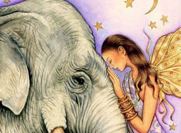 Elfje die haar hoofd tegen de slurf van een olifant houdt