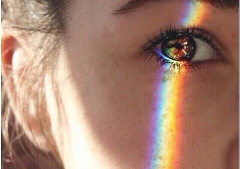 Regenboog weerspiegeld op het gezicht van een meisje