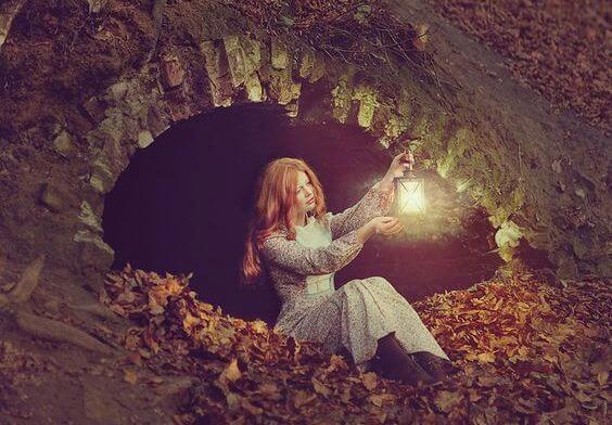 Meisje Dat In Een Grot Zit Met Een Lantaarn In Haar Hand