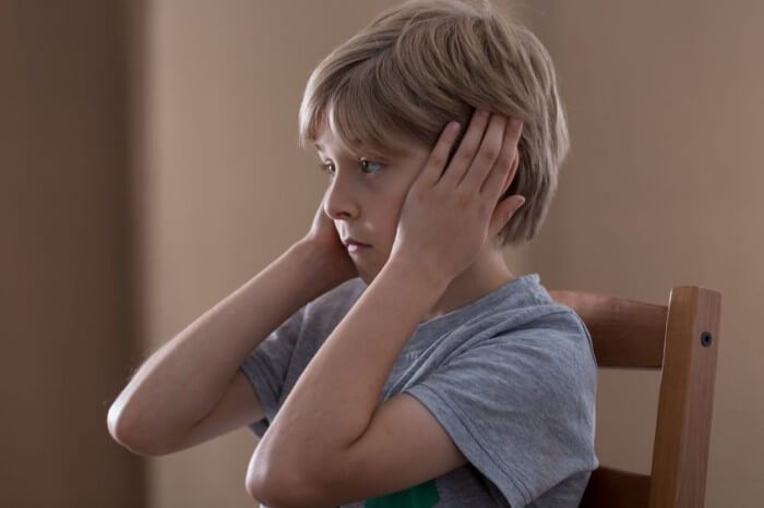 Jongen Die Zijn Oren Bedekt Met Zijn Handen Omdat Eenzaamheid Bij Kinderen Zich Steeds Vaker Voordoet