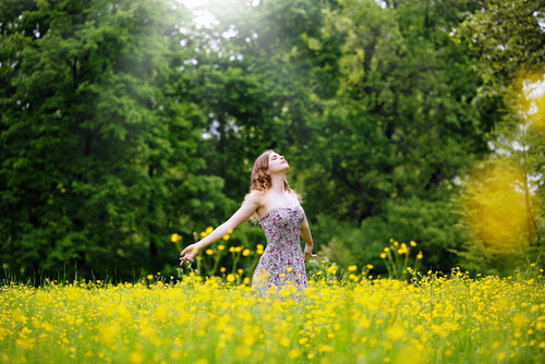 Vrouw Die In Een Grasveld Staat En Positieve Energie Uitstraalt Als Voorbeeld Van Hoe De Energie Van Anderen Ons Kan Beïnvloeden