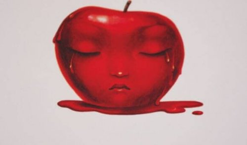 Een appel die overgoten is met rood verf waarin een gezicht in te zien is
