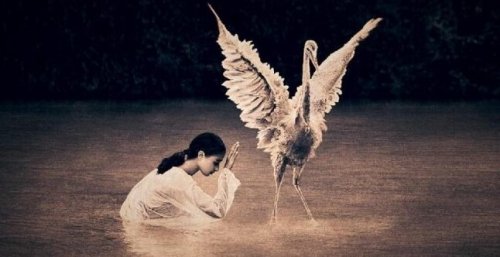 Een meisje dat knielt voor een vogel