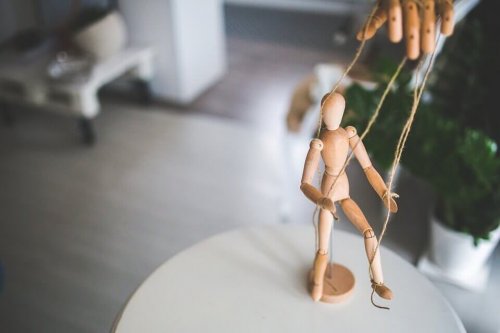 Een houten poppetje dat met touwtjes bespeeld kan worden