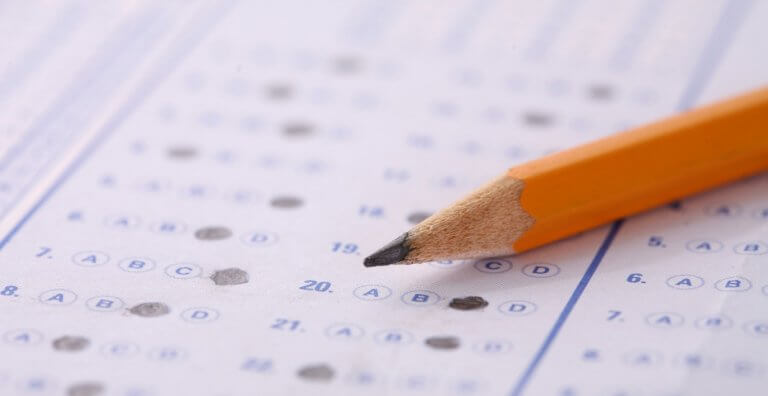 Potlood op een velletje papier waar antwoorden op staan