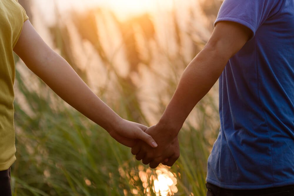 Twee mensen die elkaars handen vasthouden, maar liefde is meer dan lichamelijk contact