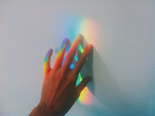 Hand raakt regenboog aan als voorbeeld voor de gave van hooggevoelige mensen.