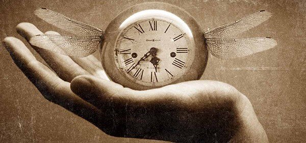 Hand waar klok op rust die vleugels heeft