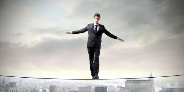 Man die heel hoog op een evenwichtskoord loopt