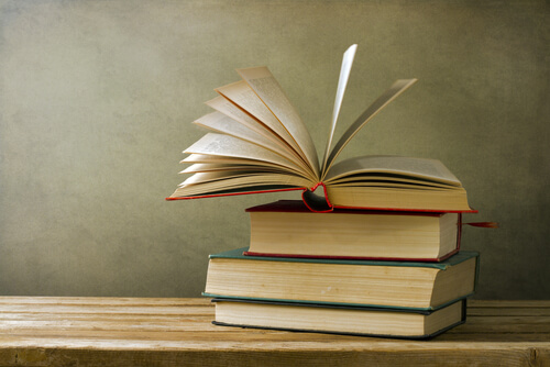 Stapel boeken waarvan het bovenste boek opgeslagen ligt