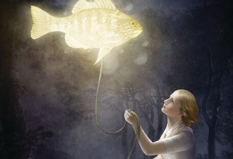 Vrouw die een vis vasthoudt aan een touw en die vis geeft licht