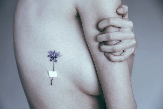 Vrouw die een tatoeage heeft van een bloem 