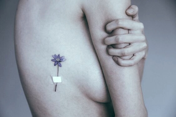 Vrouw die een tatoeage heeft van een bloem
