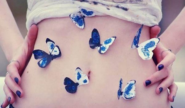 Meisje met blauwe met witte vlinders op haar buik