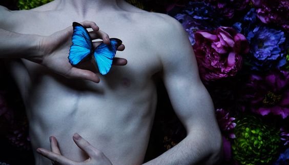 Man die een blauwe vlinder vasthoudt