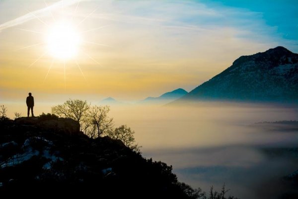 Man staat alleen op een berg en beoefent mindfulness