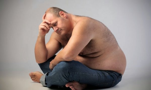 Een vrij dikke mannen die nadenkt over de relatie tussen emoties en obesitas