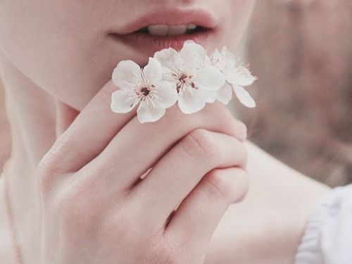 Meisje dat een paar witte bloemetjes vasthoudt als voorbeeld van hoe mooi het minimalisme kan zijn en waarom minimalist worden mooi kan zijn