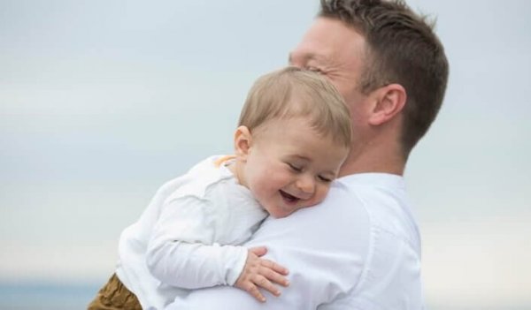 Vader die zijn zoontje knuffelt