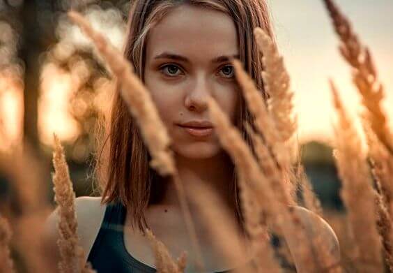 Meisje dat in een graanveld staat en een van die dappere mensen is die altijd een glimlach op hun gezicht hebben