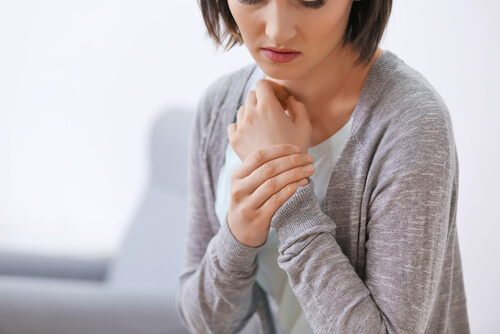 Vrouw met pijn aan haar pols, een van de plekken in het lichaam waar mensen met fibromyalgie pijn ervaren