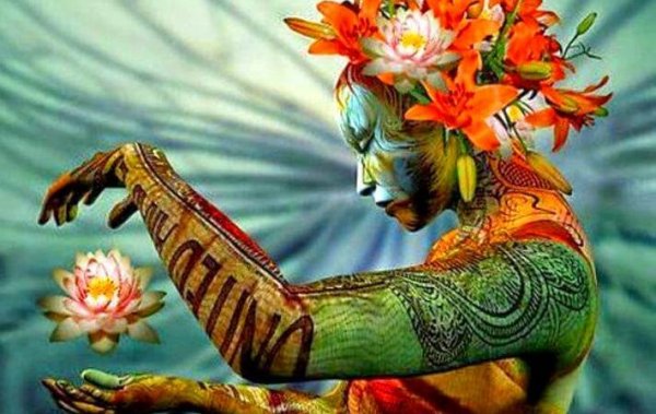 Vrouw die kleurrijk versierd is met bodypaint en een lotus tussen haar handen vasthoudt