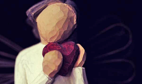 Poppetje dat haar eigen hart vasthoudt na een relatiebreuk