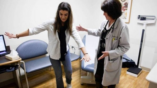 Arts helpt patiënt met multiple sclerose om te lopen