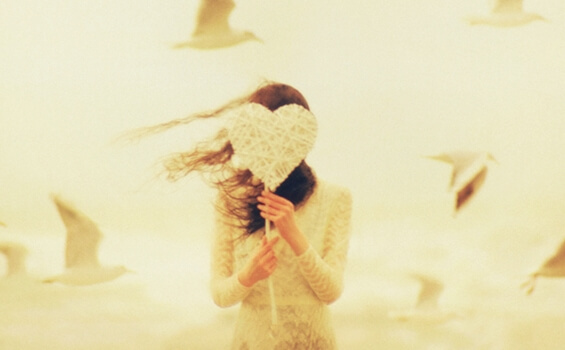 Vrouw die een hartje voor haar gezicht houdt