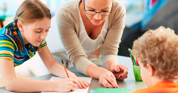 Een lerares die twee leerlingen helpt