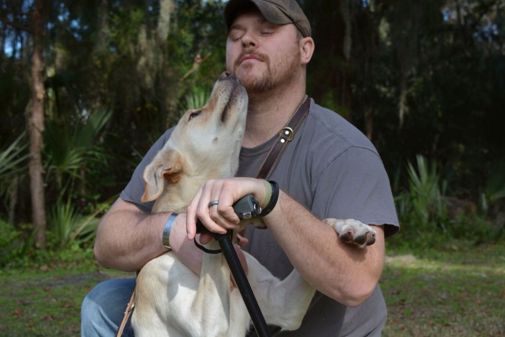 Man die geniet van de liefde van een hond door zich door hem te laten likken