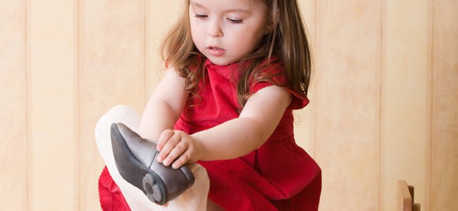 Een klein meisje dat haar schoenen aandoet