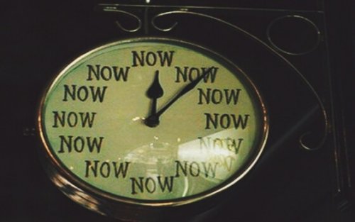 Klok waarop in plaats van cijfers twaalf keer het woord 'nu'staat, je leven veranderen kan op elk moment.