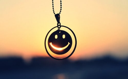 Een ketting met daaraan een smiley: je moet leren lachen om jezelf