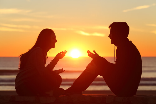 Een stel voert een positief gesprek bij zonsondergang
