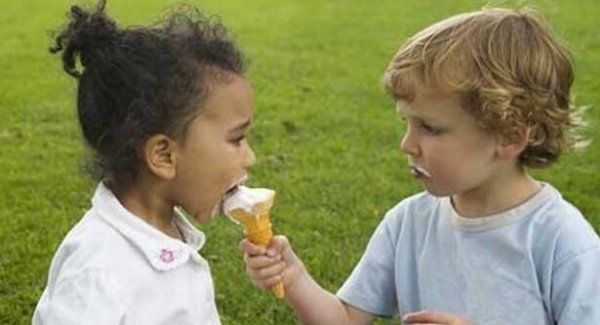 Jongetje dat zijn ijsje deelt met een meisje, want een goed mens zijn betekent delen