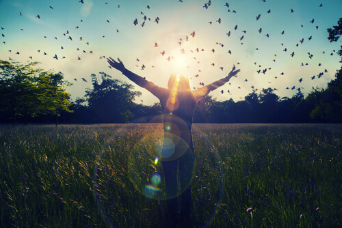 Meisje dat met gespreide armen in een veld vol vogels staat, want stoppen met therapie zal een ware bevrijding zijn