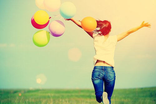 Gelukkige vrouw met kleurrijke ballonnen, maar om geluk te vinden moet je soms een risico nemen