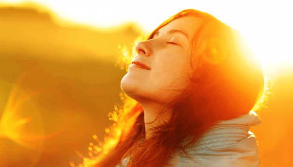 Vrouw die geniet van de zon op haar gezicht