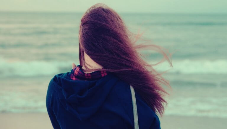 Meisje dat uitkijkt over de zee