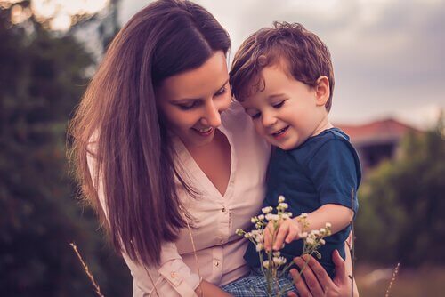 Moeder die met haar zoontje naar bloemen kijkt, want ze is geen slechte moeder