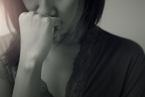 Meisje dat zich schuldig voelt na het verbreken van een relatie en haar hand tegen haar mond houdt