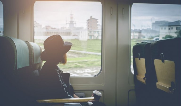 Meisje dat in de trein zit en uit het raam kijkt en nadenkt over het verbreken van een relatie
