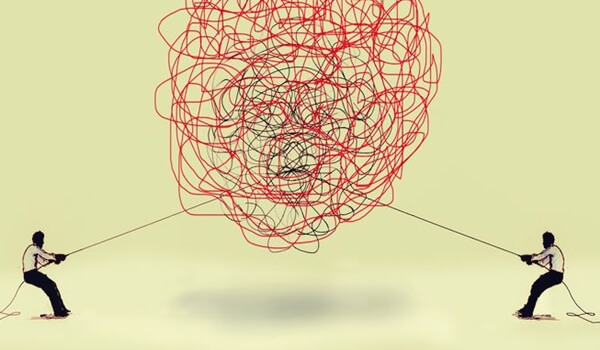 Twee mensen trekken ieder aan een ander uiteinde van een ingewikkelde knoop