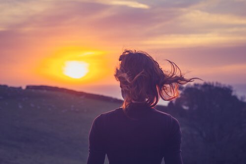 Vrouw kijkt naar de zon en weet: leven in het heden is belangrijk