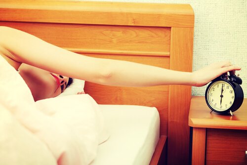 Vrouw die haar wekker uitzet