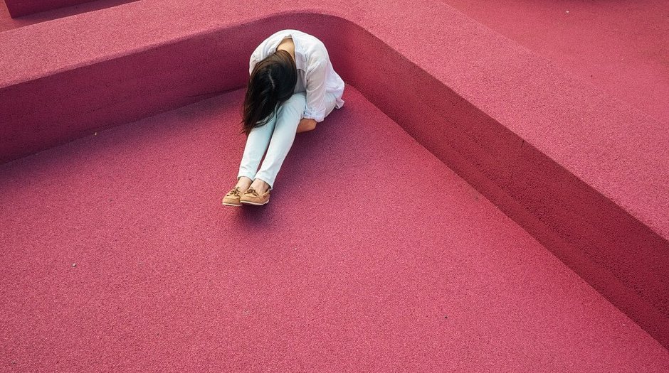 Vrouw die voorover gebogen zit want zij is een van die mensen met chronische pijn