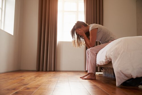 Vrouw die huilend op haar bed zit omdat ze last heeft van vaginisme