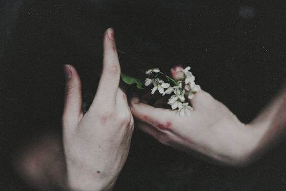 Twee handen met bloed en bloemetjes