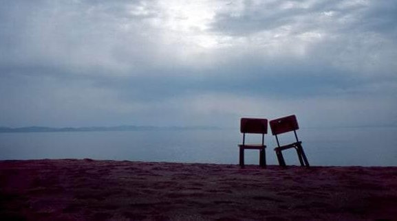 Twee eenzame stoelen op een strand